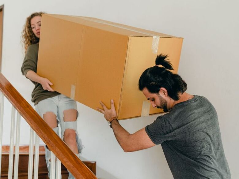 Tetris Moving crew building a tight wall of boxes and furniture inside a box truck on an Omaha street